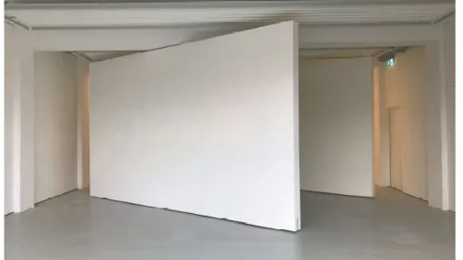 Eine weisse Wand steht diagonal in einem white cube Ausstellungsraum