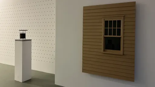 Bernard Voïta - Insomnie Géométrique bei Edizioni Galleria Periferia, Rechts: Wandskulptur einer Fassade mit Fenster, links ein Sockel mit einer kleinen schwarzen Skulptur darauf