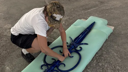 Künstlerin Kika Vilela mit einer blauen Skulptur aus Ton